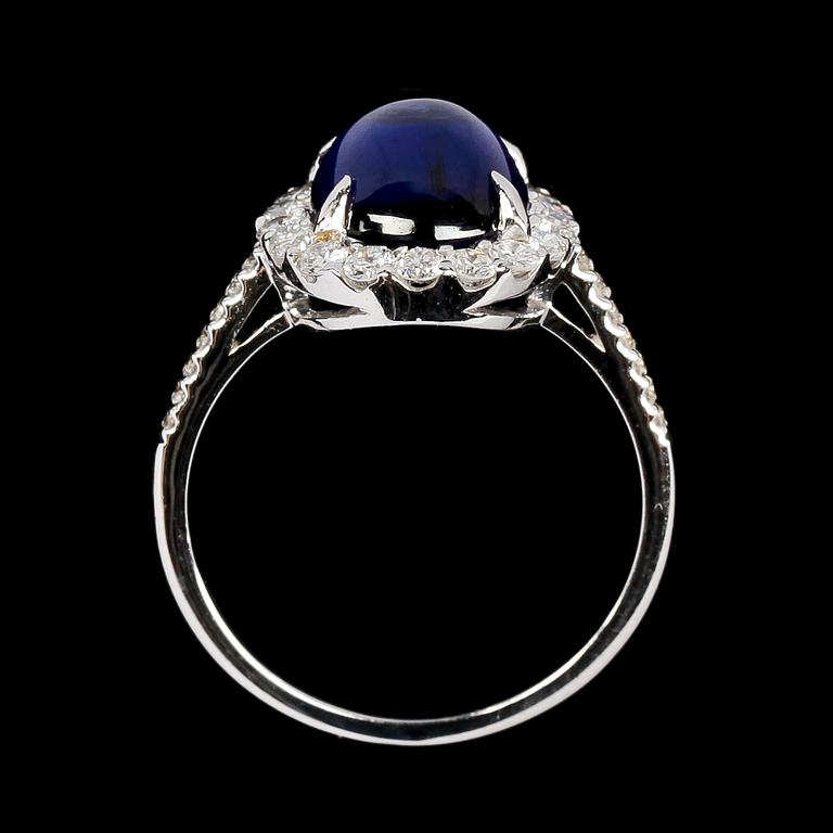 RING, cabochonslipad blå safir, 4.14 ct samt briljantslipade diamanter, tot. 0.68 ct.
