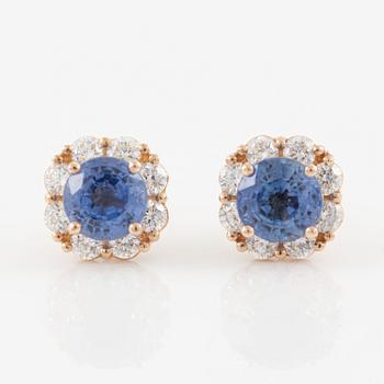 A pair of 14K gold earrings with faceted sapphires and round brilliant-cut diamonds.