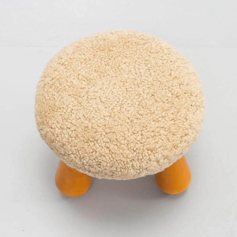 A Swedish, new produced stool with birch legs and sheepskin upholstery.