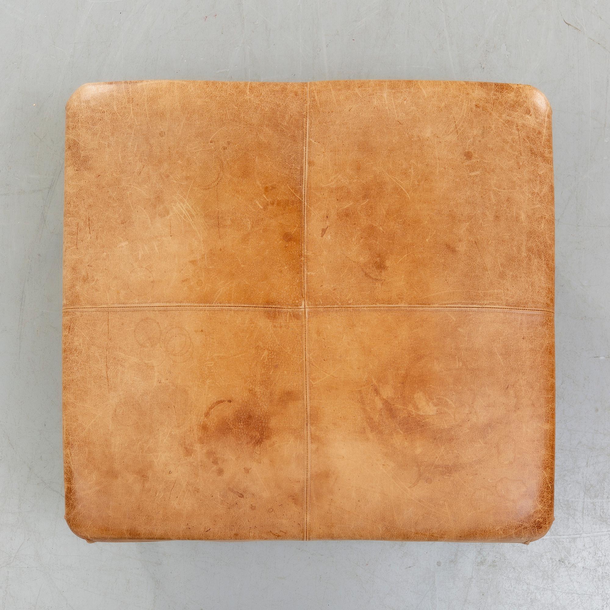 A leather ottoman/coffee table alter part of the 20th century.