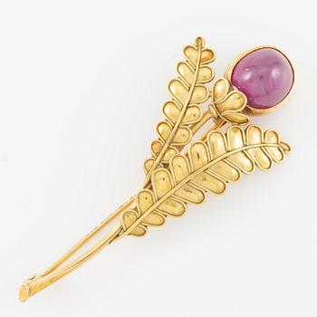 Brooch, 18K gold with cabochon-cut ruby, decoration of leaves.