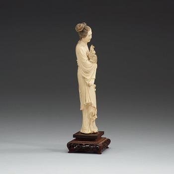 A carved ivory figure of an elegant lady and her dog, Qing dynasty (1644-1912).