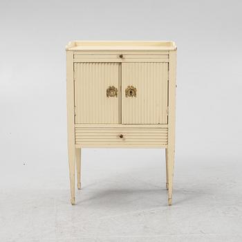 A Gustavian style painted bedside cabinet from around the year 1900.
