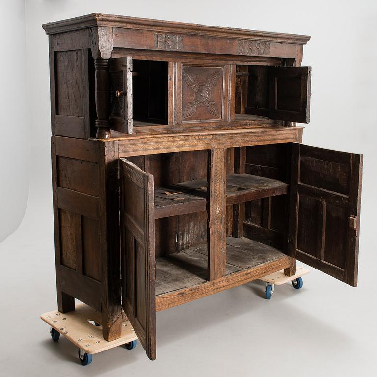 A QUEEN ANNE COURT CUPBOARD, oak, England dated 1697.