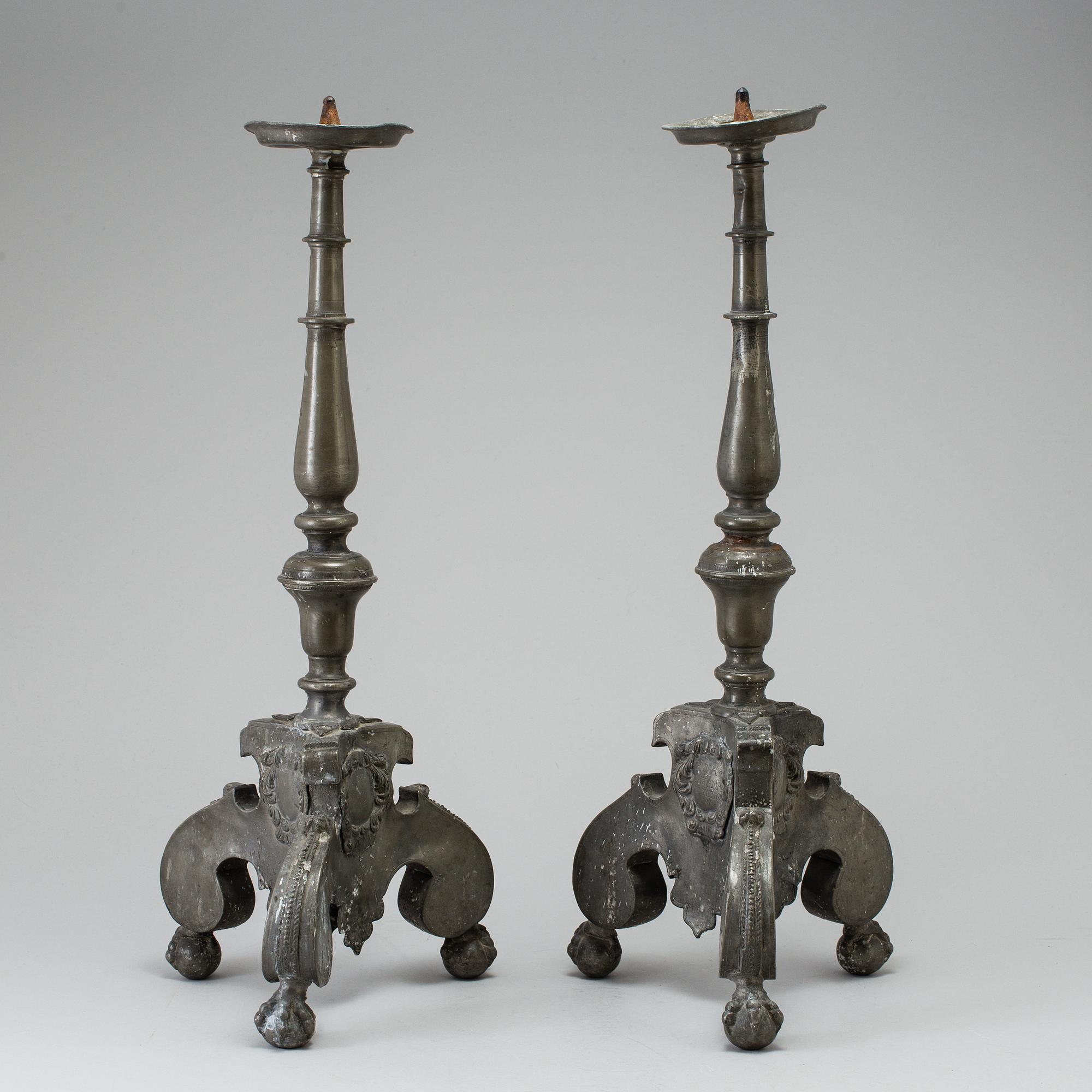 A pair of baroque pewter candlesticks, engraved date 1699.