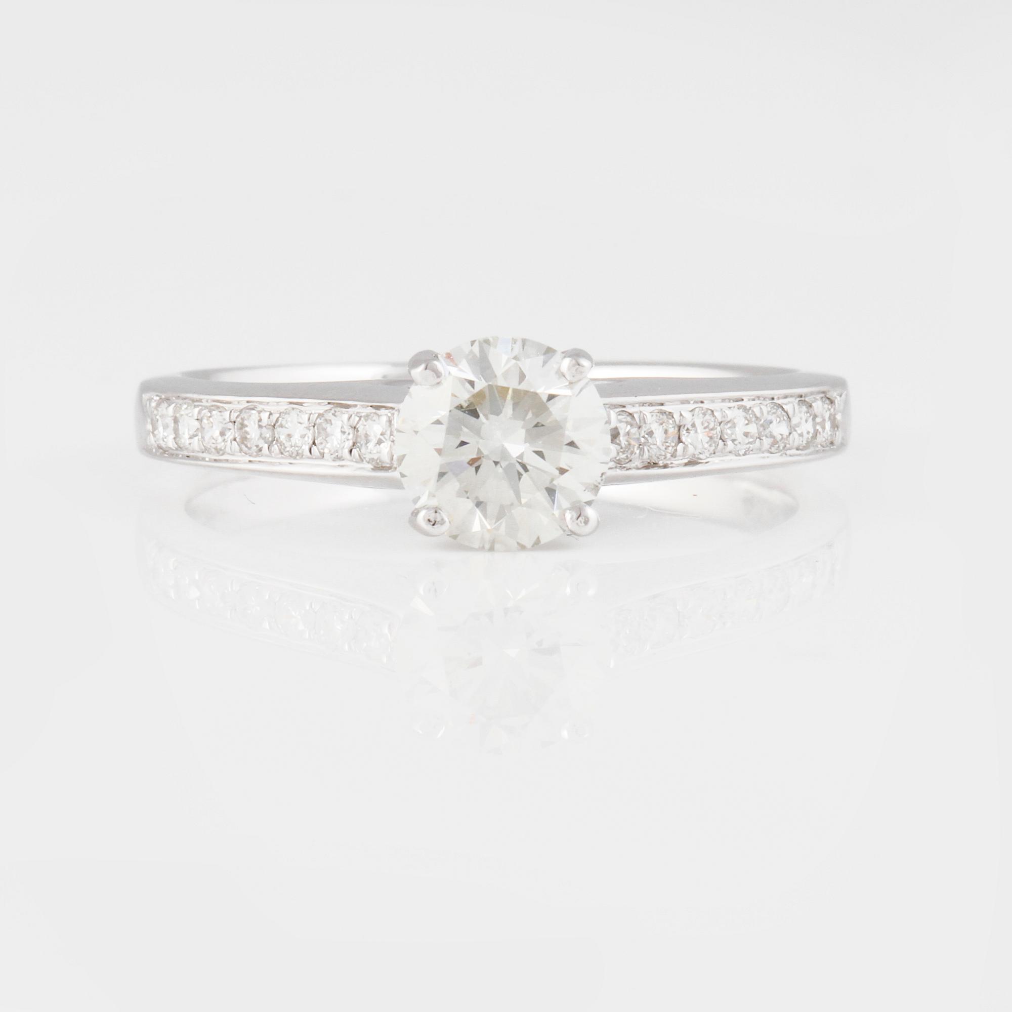 RING, 18K vitguld med briljantslipad diamant ca 0.70 ct samt små briljantslipade diamanter ca 0.15 ct. Vikt 2,9 gram.