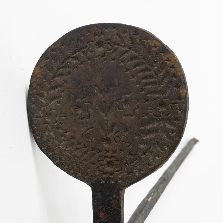 An iron wafer maker, dated 1662.