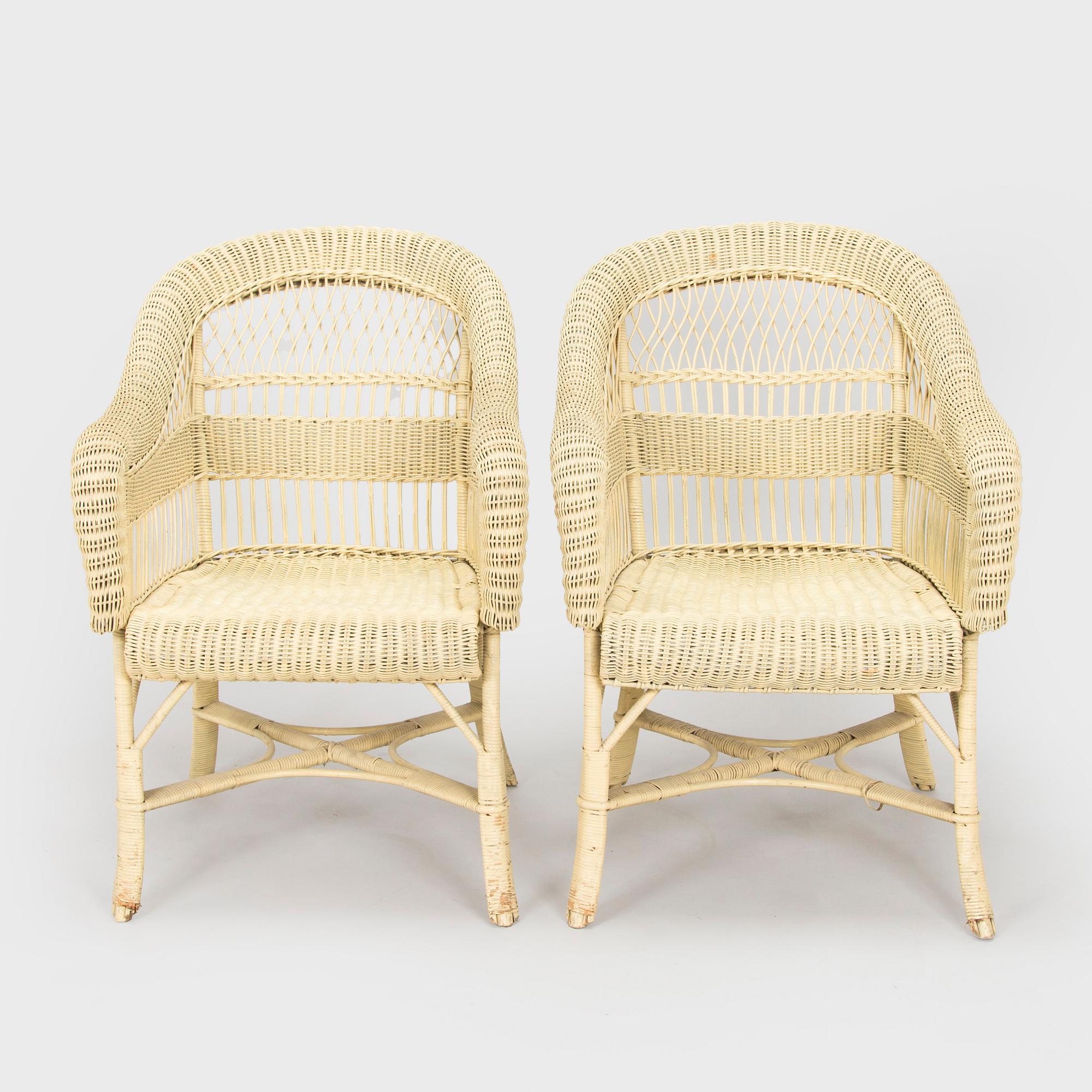 A mid-20th-century three-piece rattan furniture set including two armchairs, and a table.