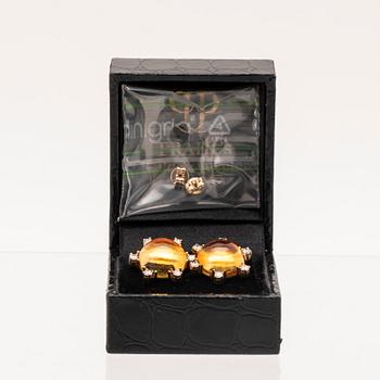 A pair of 18K gold earrings set with cabochon cut citrines and round brilliant cut diamonds.