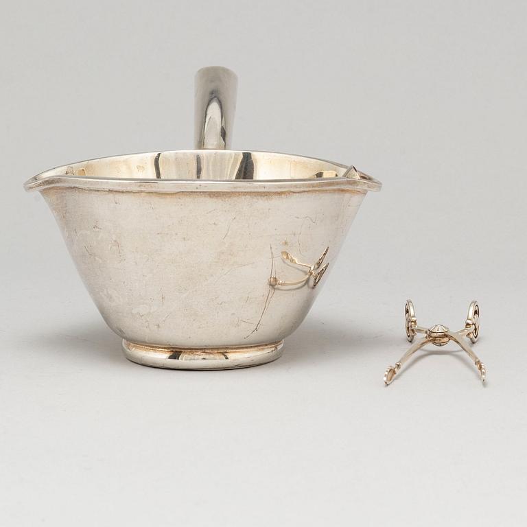 A Mexican sterling silver sauce pan and a Georg Jensen sugartangs, 20th century.