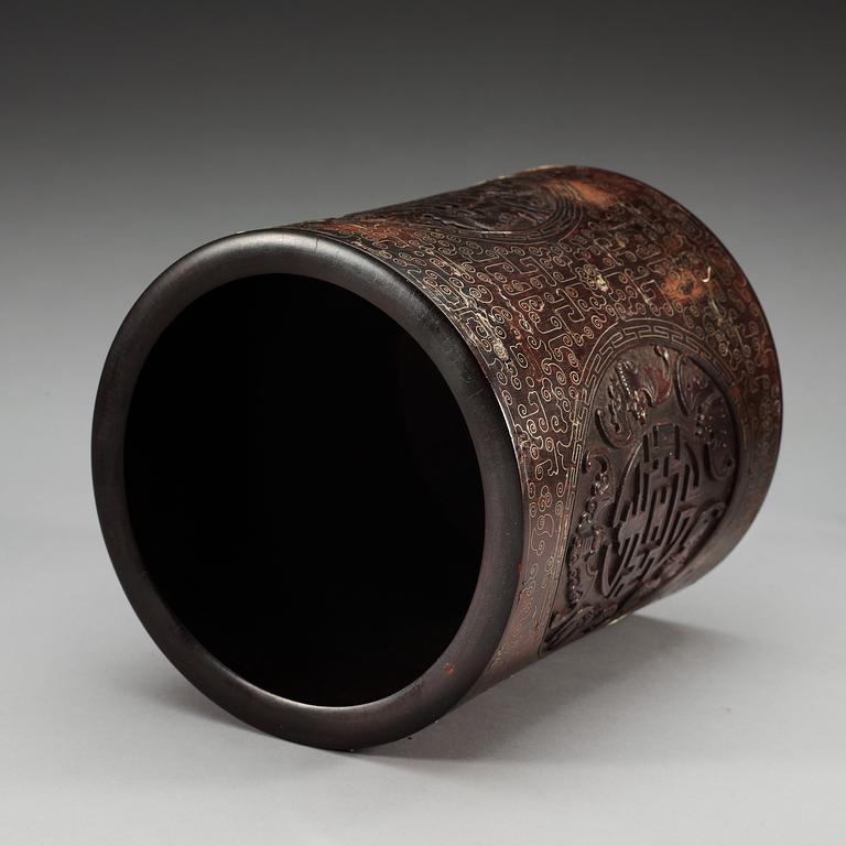 A carved wooden brush pot with metal inlay, Qing dynasty.