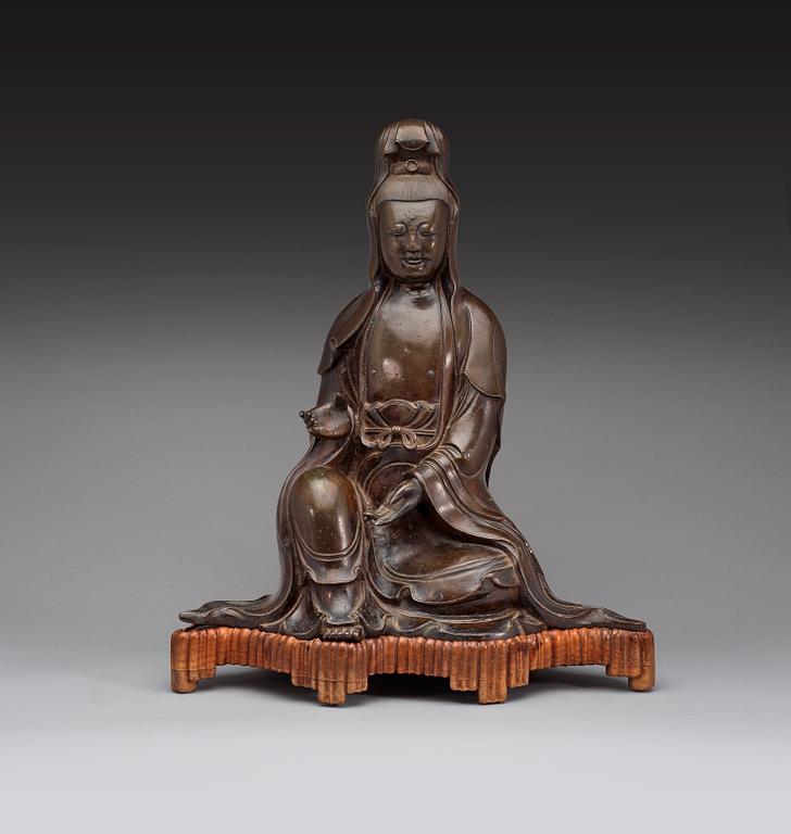 A large bronze figure of a seated Guanyin dressed in a flowing robe, Ming dynasty, 17th century.