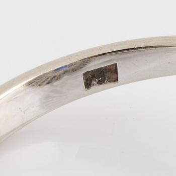 Ring 18K vitguld med en fasettslipad safir och trapetsslipade diamanter.