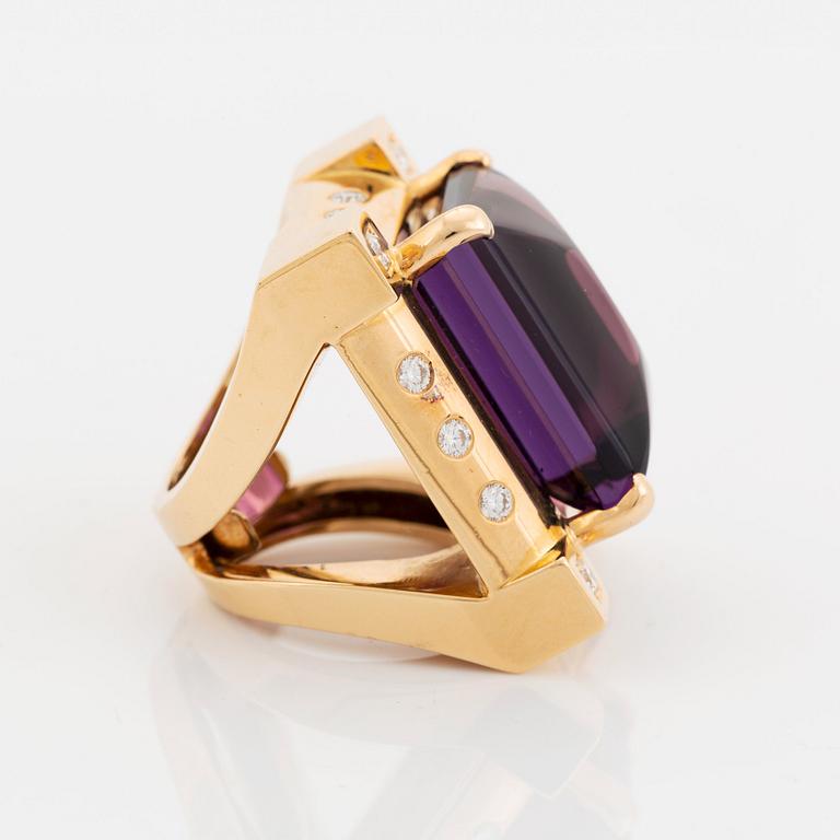 An 18K gold Acchinelli ring set with a faceted amethyst and round brilliant-cut diamonds.