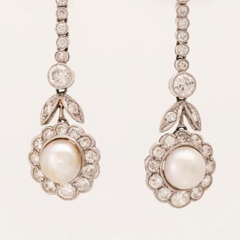 A pair of 18K white gold earrings set with cultured pearls and round brilliant-cut and old-cut diamonds.