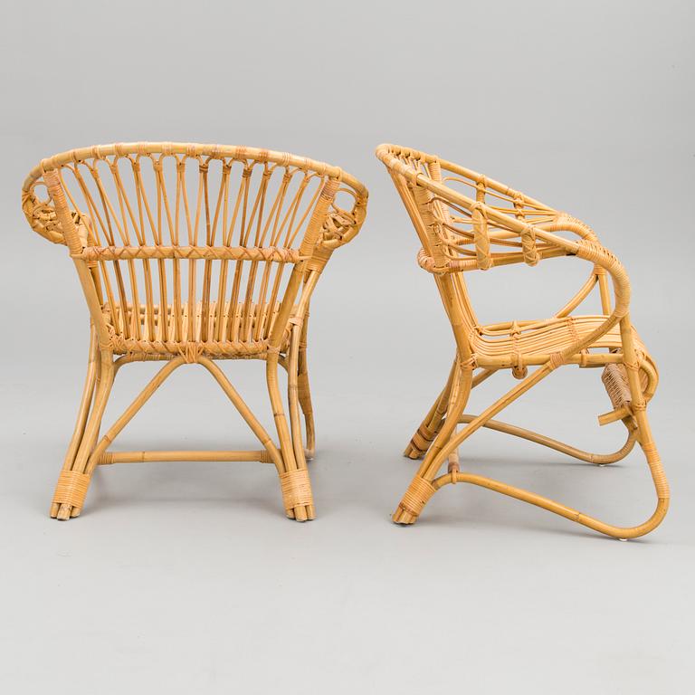 A pair of rattan arm chairs from the latter half of the 20th Century.