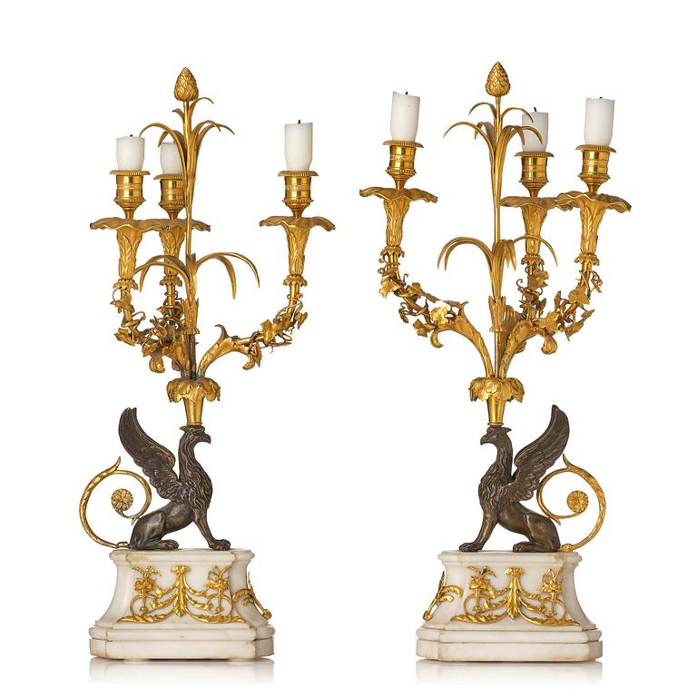 A pair of three-light Louis XVI patinated and ormolu candelabra in the manner of François Rémond, late 18th century.