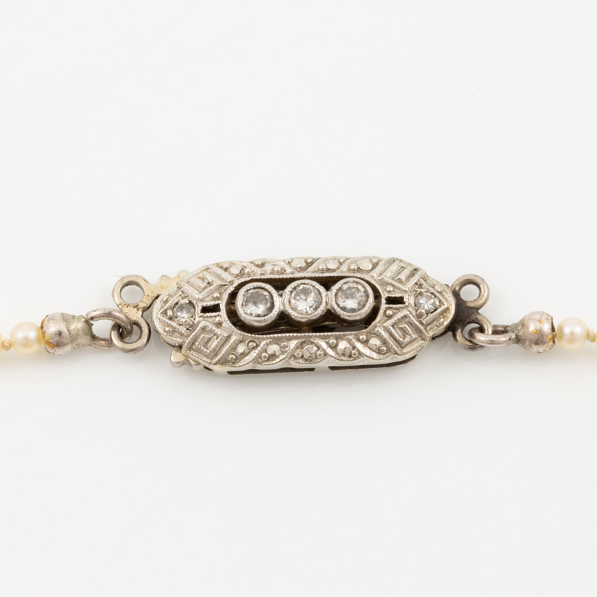 Pearl necklace, graduated pearls, clasp in 18K white gold with small diamonds.