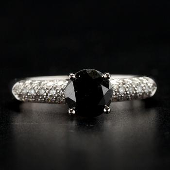 RING, vitguld 18K, svart diamant 1,15 ct, små diamanter tot. 0,40 ct. Vikt 3,5 g.