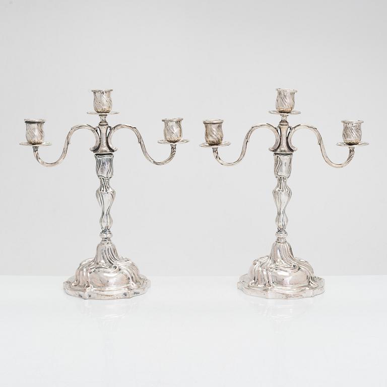 A pair of 18th-century Rococo silver candlesticks from Germany with later candelabra arms. Unindtified maker's mark.