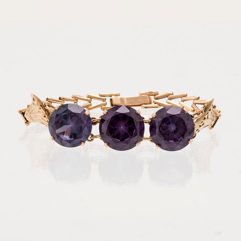 Bracelet, ring, and brooch in gold with synthetic colour-changing sapphires and glass.