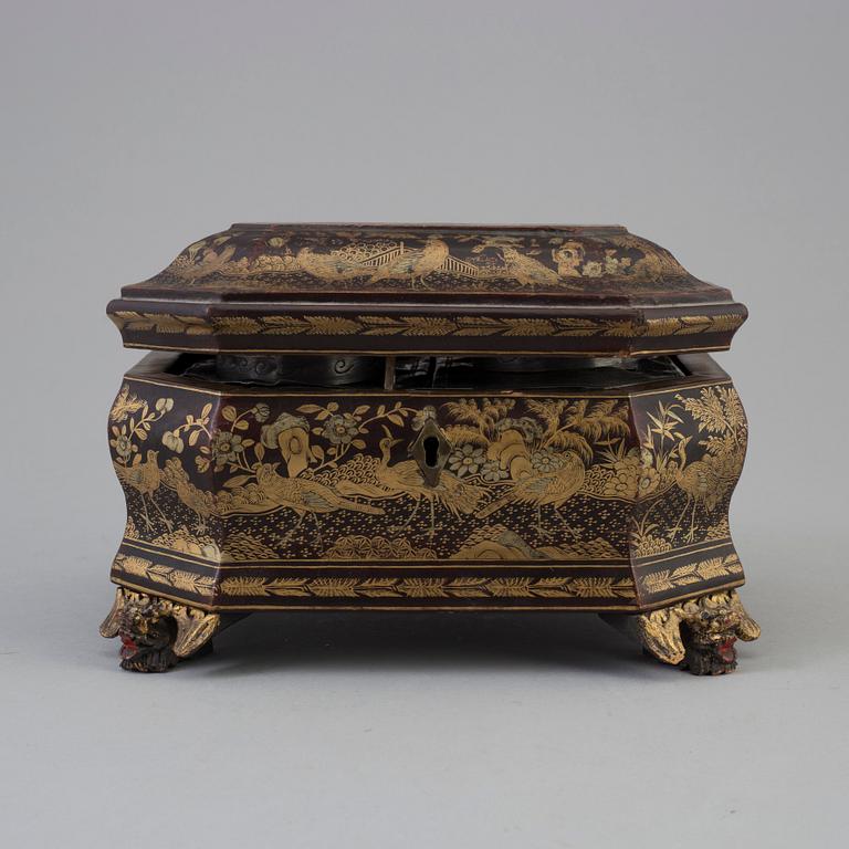 A Chinese lacquered box with cover with two pewter tea caddies, Qing dynasty, 19th Century.