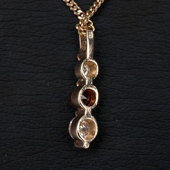 HÄNGE I KED, guld 14K, 2 diamanter tot. 0,34 ct, och en granat 0,32 ct. Vikt 4,1 g.