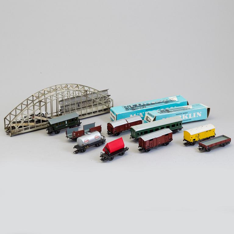 A set of Märklin electric trains, wagons,  rails, and a bridge.