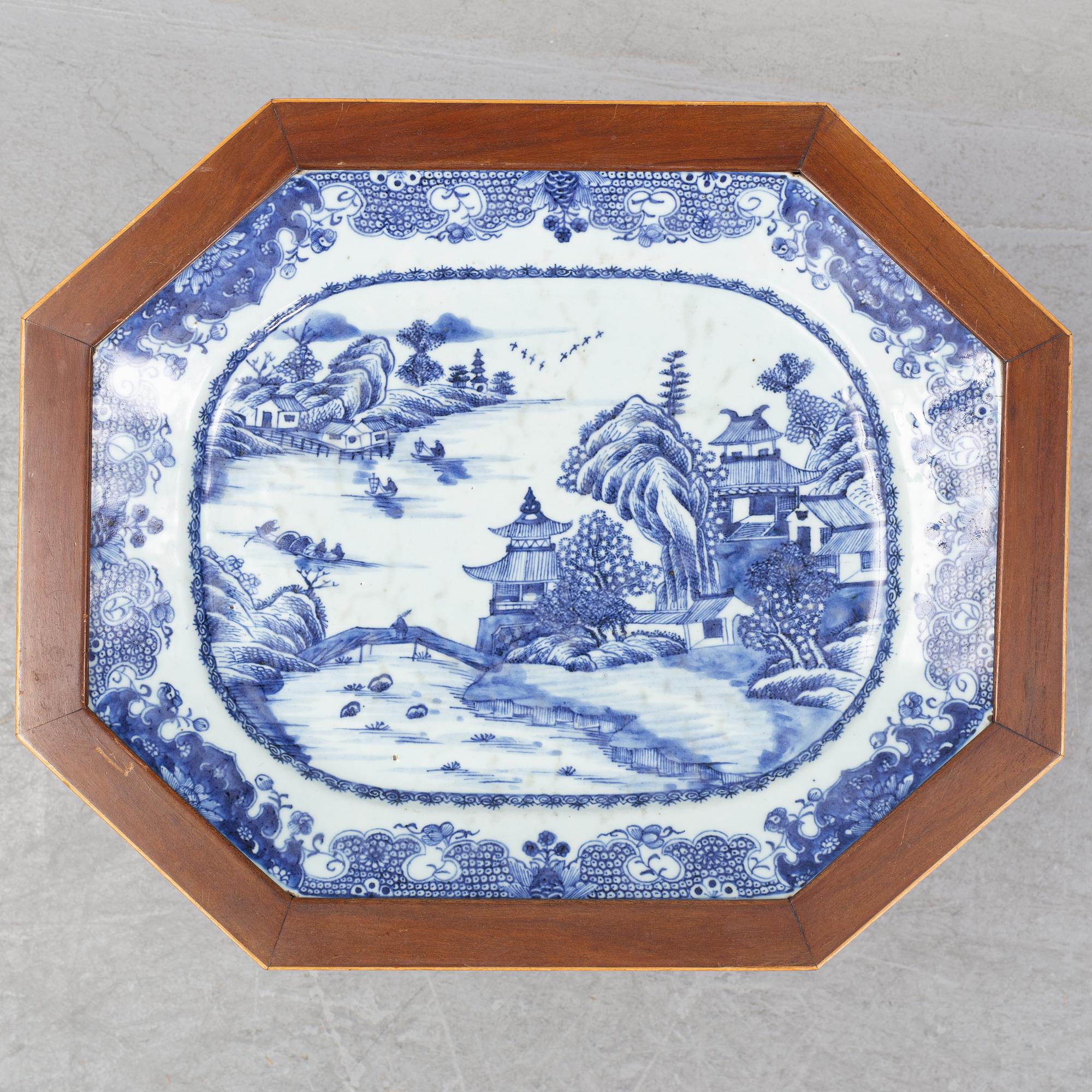 A mahogany veneered table with a Chinese blue and white porcelain charger, Qianlong (1736-95).