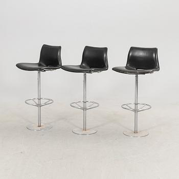 A set of three late 20th century metal and leather bar stools.