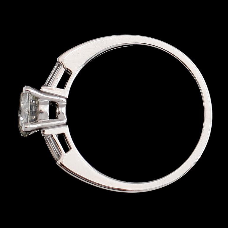 RING, 18 k vitguld, solitär briljantslipad diamant ca 1.00 ct, 2 baguetteslipade diamanter tot ca 0.16 ct.