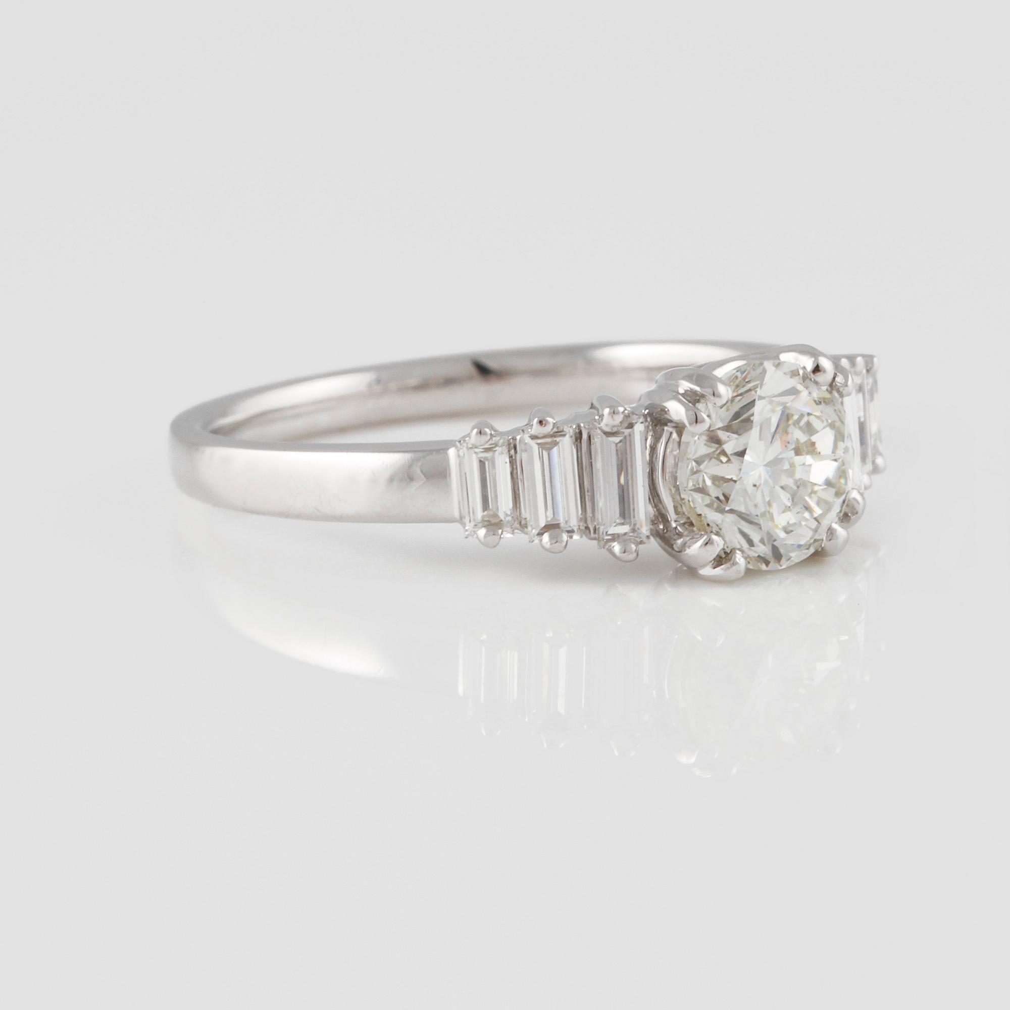 RING, 18K vitguld med briljantslipad diamant ca 1.01 ct samt baguetteslipade diamanter ca 0.29 ct. Vikt 4,0 gram.
