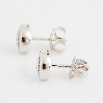 A pair of 14K gold earrings set with round brilliant-cut diamonds.