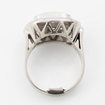 Oval-shaped 18K white gold ring with a brilliant-cut diamond and octagonal-cut diamonds.