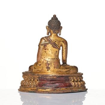 A gilt copper alloy figure of Buddha, Tibet/Nepal 15th Century.