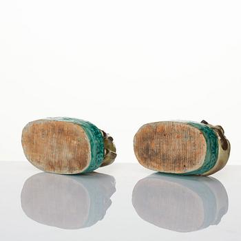 A pair of green, yellow and aubergine glazed biscuit figures of recumbent horses, Qing dynasty.