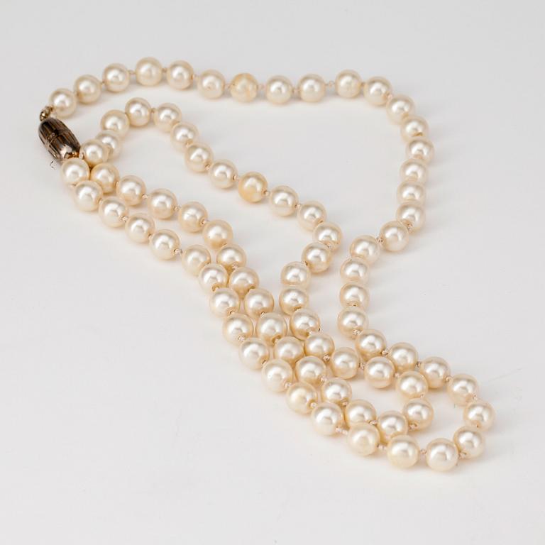 CÉLINE, a decorative white pearl necklace.