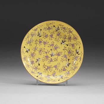 77. A yellow ground famille rose dish, Late Qing dynasty, with Qianlong six character mark.