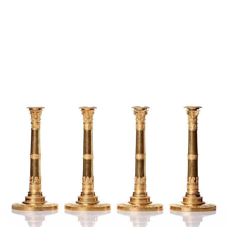 A set of four Empire presumably Russian candlesticks in gilded bronze.