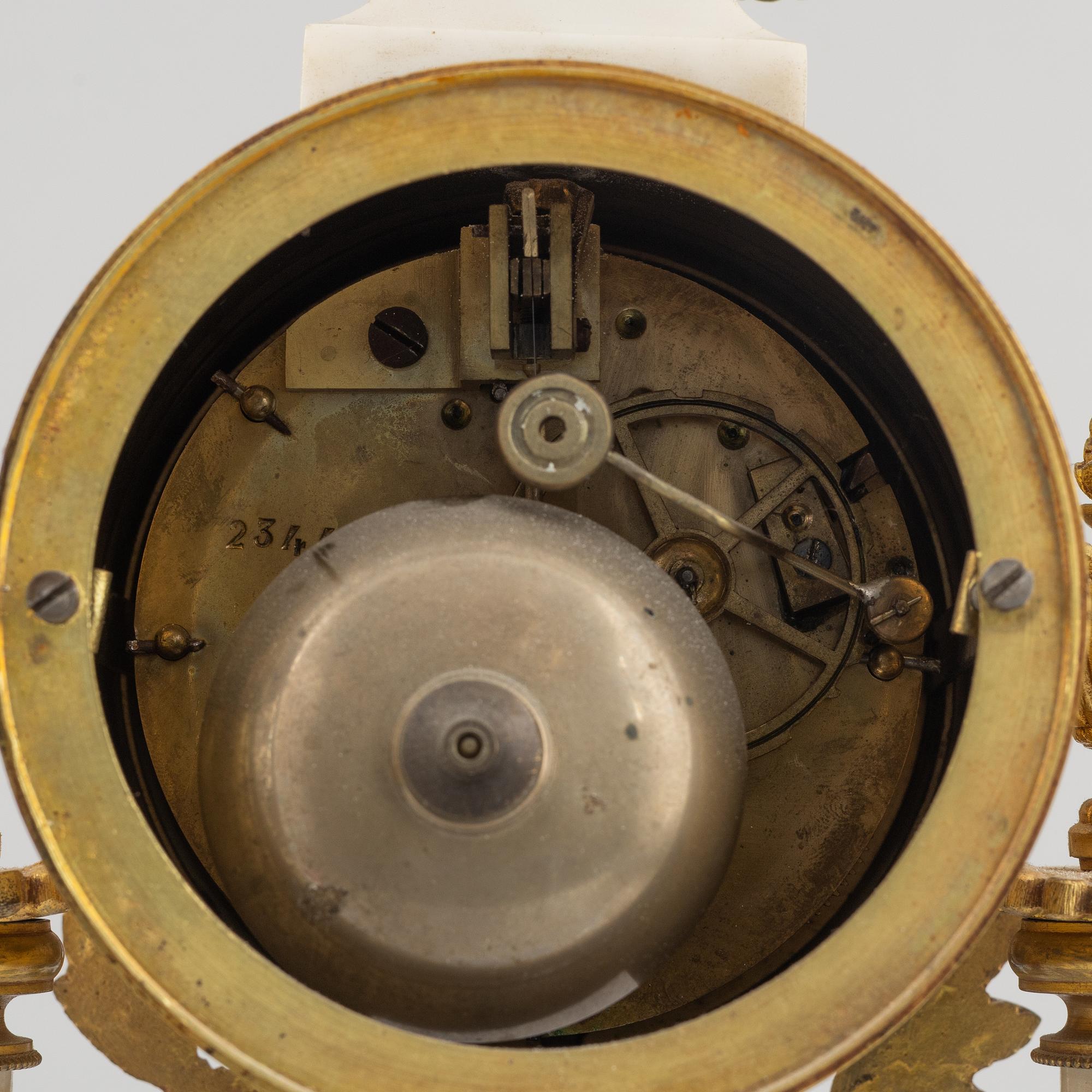 A Louis XVI-style mantel clock Paris, France and a pair of candelabras, late 19th century.