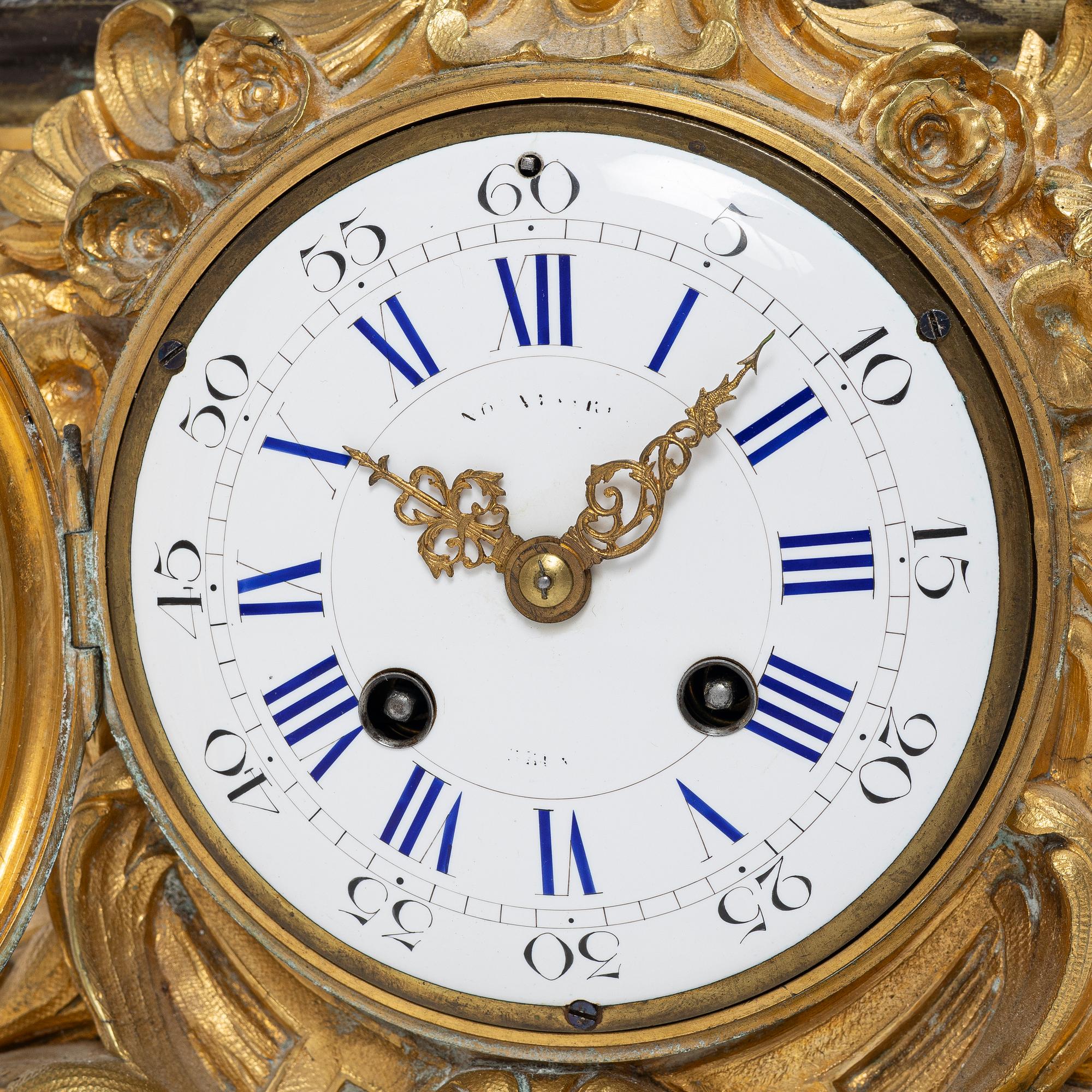 A Rococo style mantle clock and pair of candelabra, France, late 19th Century.