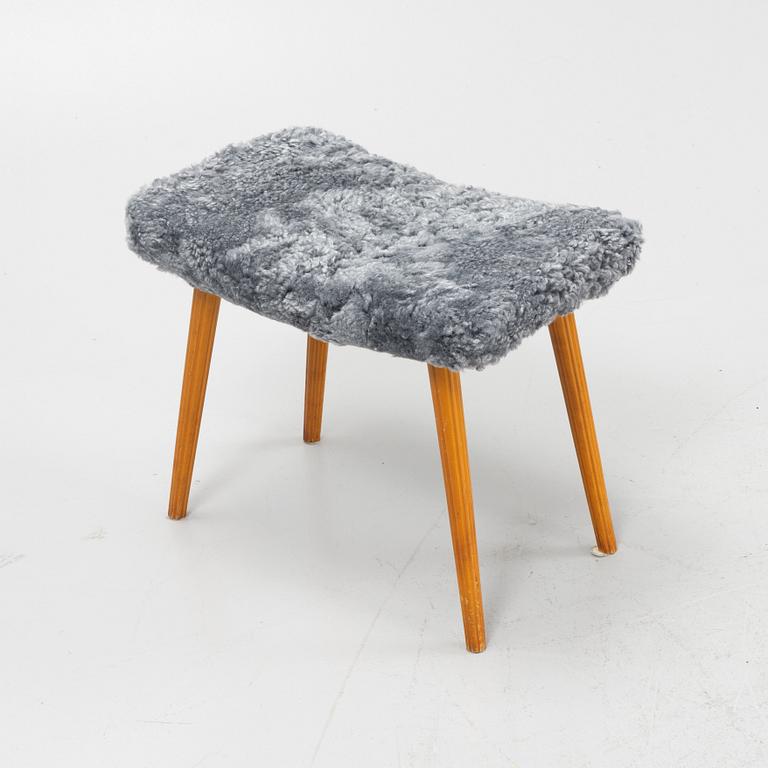 A mid 20th Century stool with new sheepskin upholstery.