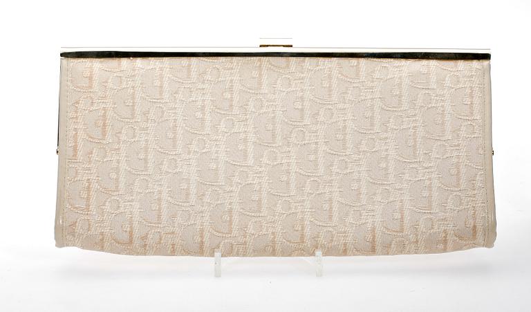 A white monogram canvas clutch by Christian Dior.