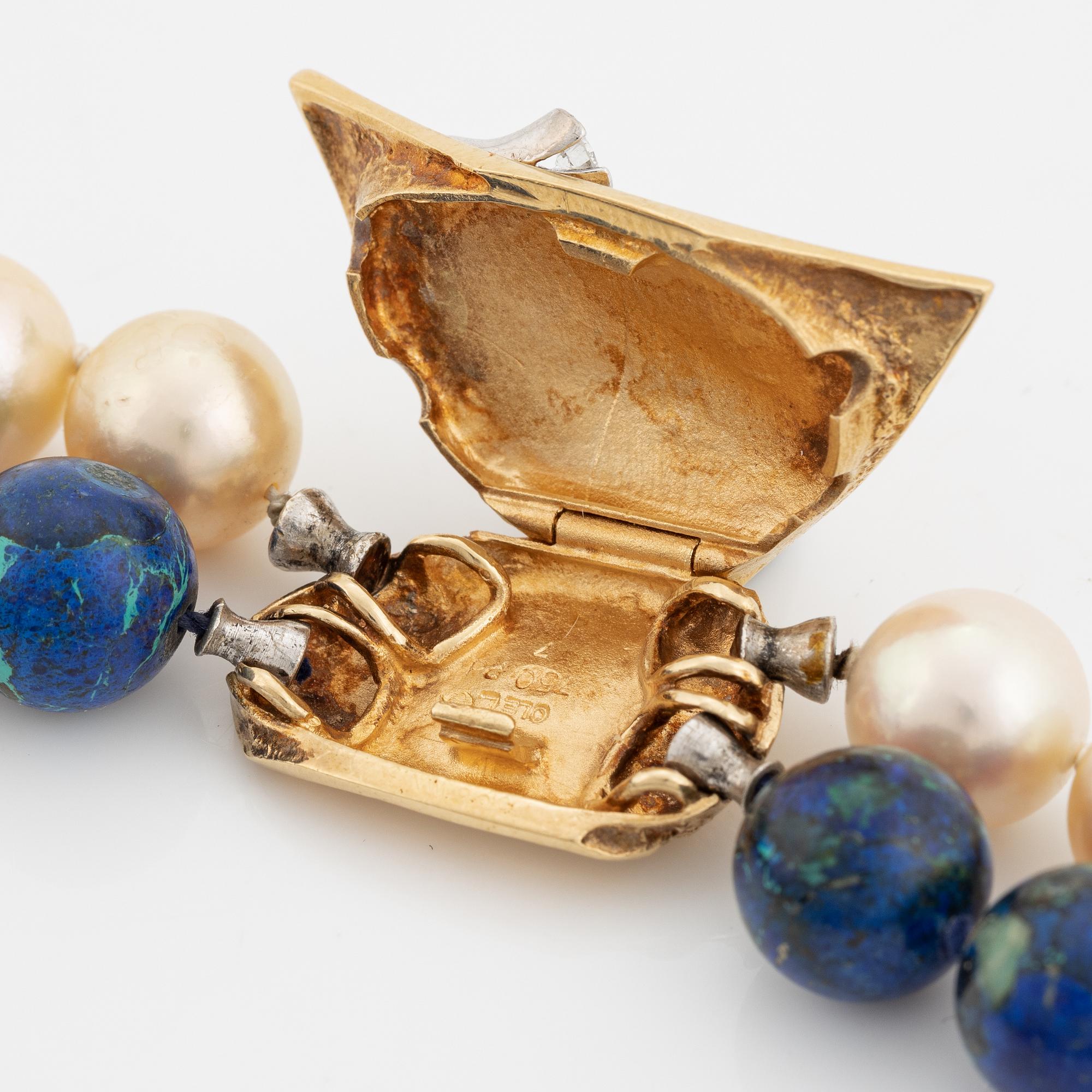 Ole Lynggaard, spänne i  18K guld med briljantslipad diamant.