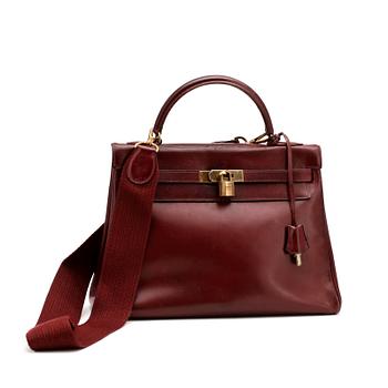 HERMÈS, a burgundy read leather "Kelly 32" bag, 1960's.