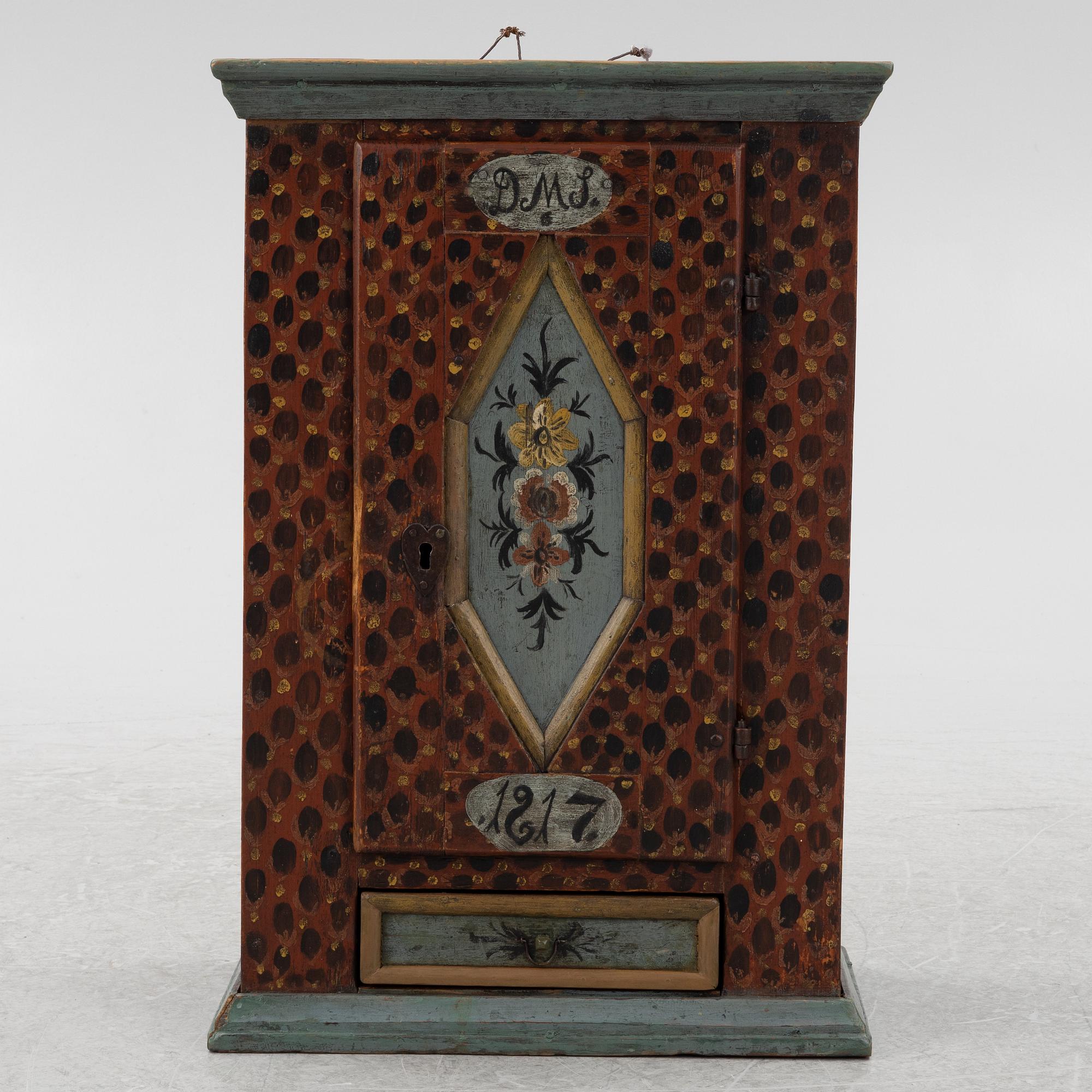 A painted wall cabinet, dated 1817.