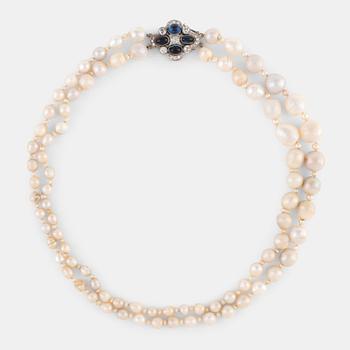 1064. A two strand natural pearl-necklace Ø 4.10-10 mm with smaller pearls between.