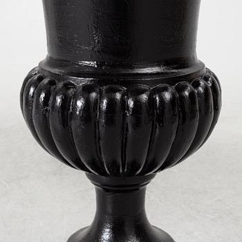A pair of cast iron garden urns, 20th century.
