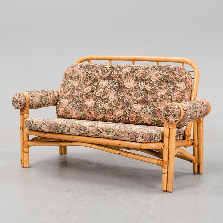 A set of two garden sofas, an armchair and a glass table, later part of the 20th Century.