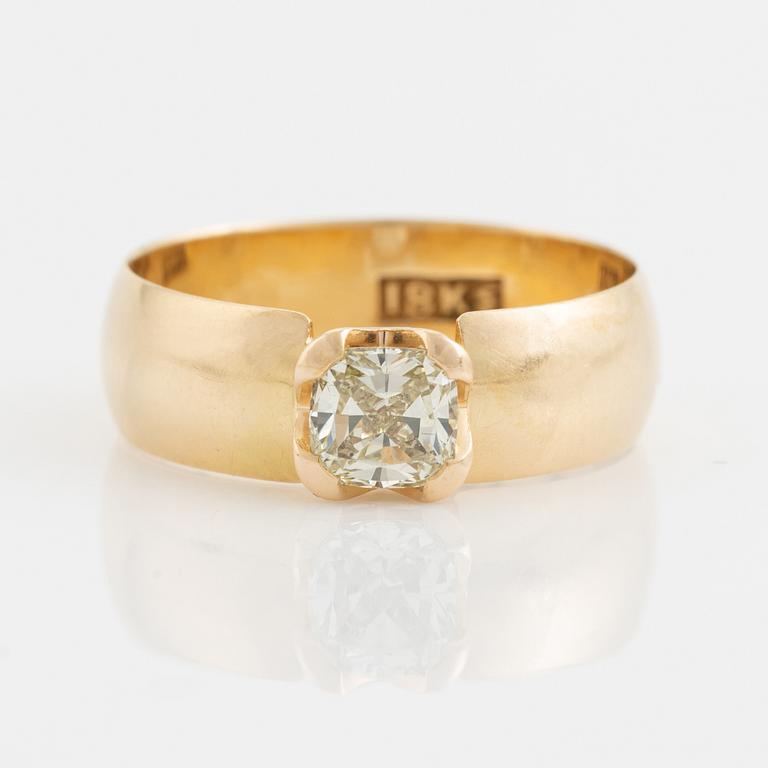 An 18K gold ring set with a radiant-cut diamond.